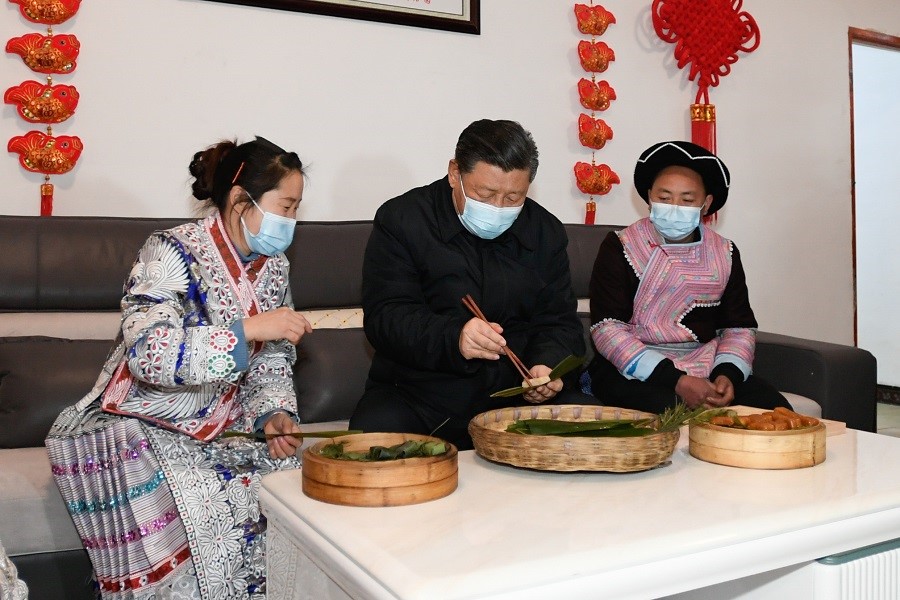 2021年2月3日下午，習(xí)近平在貴州畢節(jié)市黔西縣新仁苗族鄉(xiāng)化屋村苗族村民趙玉學(xué)家，同一家人邊聊家常邊制作當(dāng)?shù)貍鹘y(tǒng)節(jié)日食品黃粑。新華社記者 李學(xué)仁 攝